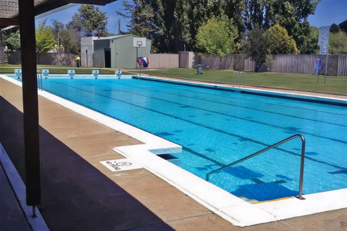 Clean pool water at Bombala Pool, trees and grass in the background