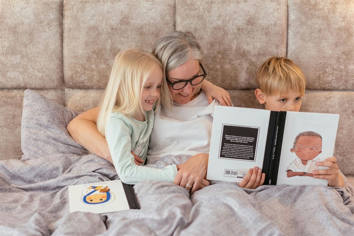 Grandmother reading picture book with her two grandchildren