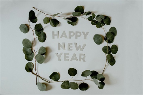 Happy New Year lettering surrounded by eucalypt garland