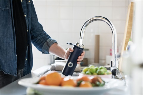 Man filling drink bottle from kitchen tap.jpg