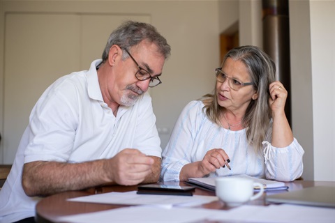 Older couple with papers and laptop