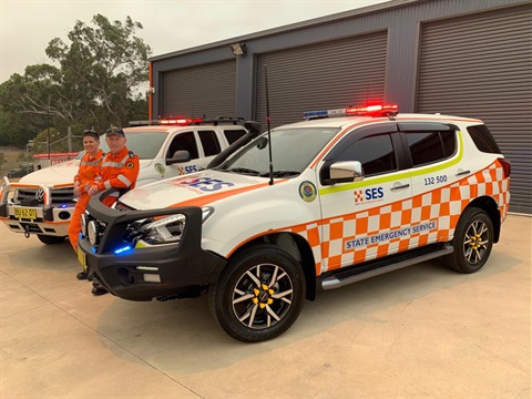 Volunteers with the NSW SES pose for a photo with SES vehicles